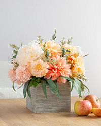 Flowers in a vase next to apples