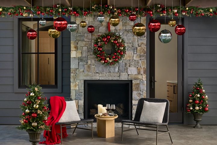 Patio décor idea with a Christmas wreath, garland, and potted arrangements