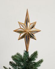 A mirrored star tree topper attached to a Christmas tree
