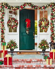 Front porch decorated with red and gold Christmas greenery