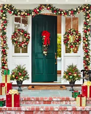 Front porch decorated with red and gold Christmas greenery