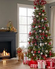 Rote und weiße Weihnachtskugeln an einem schmalen Baum