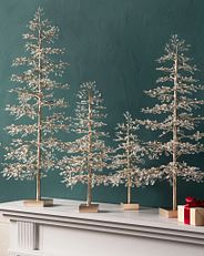 Eine Gruppe kleiner Weihnachtsbäume mit Kristall- und Perlenakzenten