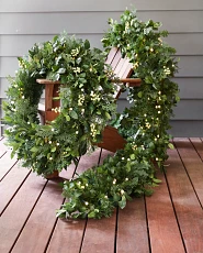 Cypress and white berry wreath and garland on a deck chair