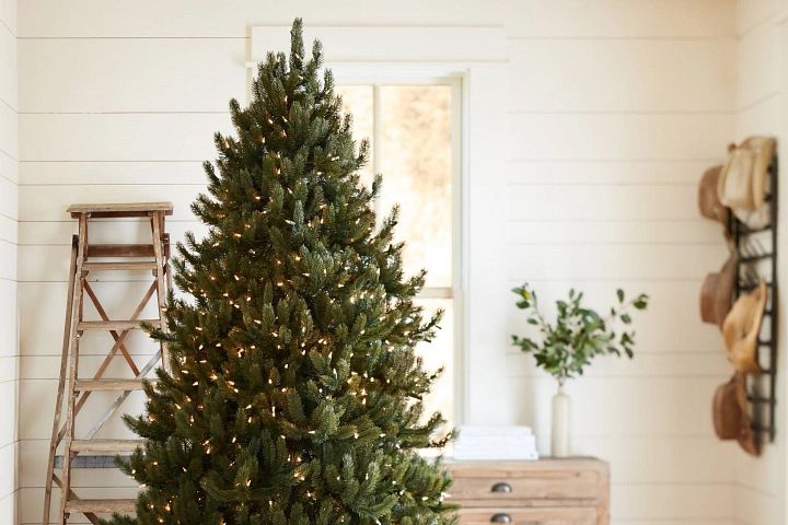 Ein beleuchteter Weihnachtsbaum in einem weißen Raum