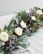 Artificial flower garland with ranunculus, waxflower blooms, silver brunia, and assorted leaves