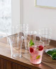 Clear glass tumblers with pink beverage, raspeberries, and mint