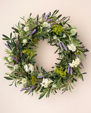 Spring wreath made with artificial purple cattails, white lilacs, thistle, and mixed greenery