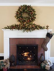 A fireplace mantel decorated with a wreath and garland