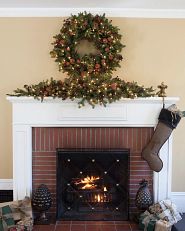 A fireplace mantel decorated with a wreath and garland