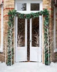 The façade of a house decorated with garlands and twig trees