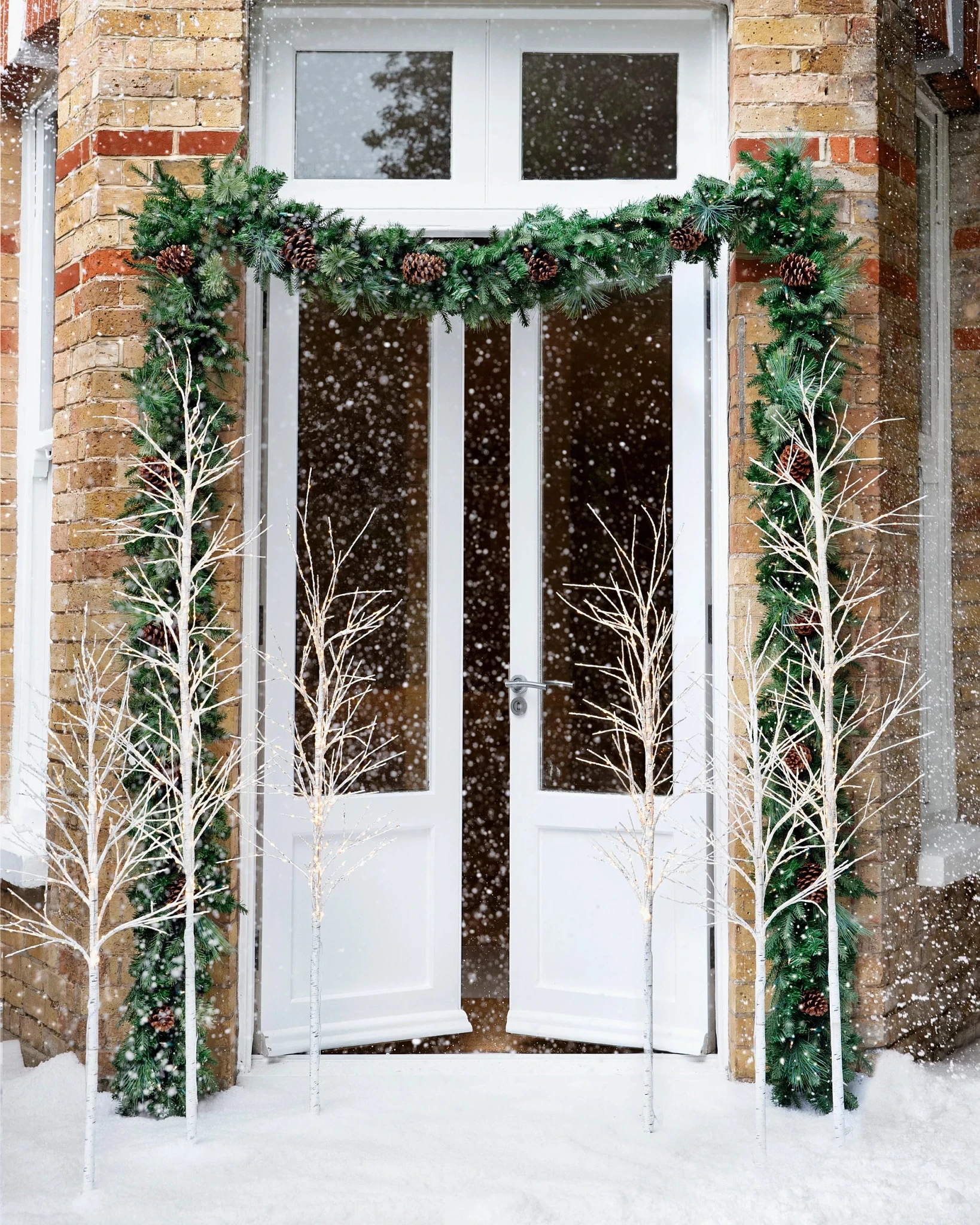 The façade of a house decorated with garlands and twig trees