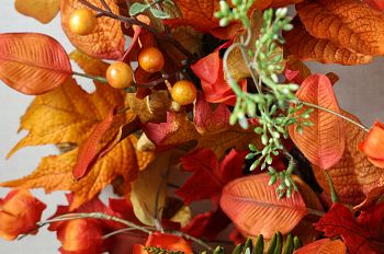 Close-up of artificial fall wreath with assorted leaves