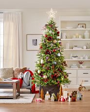 Artificial Christmas tree decorated with farmhouse-themed ornaments and dark brown wooden crate collar