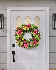 Pink, red, and yellow flower wreath on white door