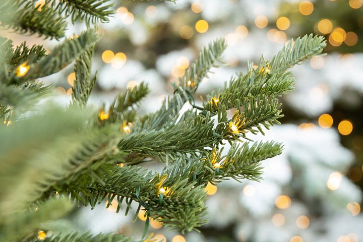 Nahaufnahme des Zweigs eines künstlichen Weihnachtsbaums mit Lichtern