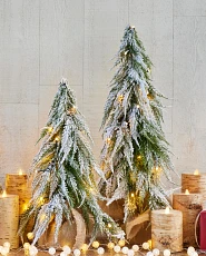 Künstliche Weihnachtsbäume in Miniaturform mit schneebedeckten Ästen