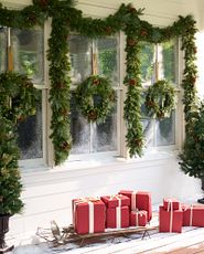 Exterior-facing window decorated with green Christmas wreaths and garlands