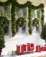 Exterior-facing window adorned with green Christmas wreaths and garlands
