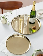 Pair of brass serving trays on a white table