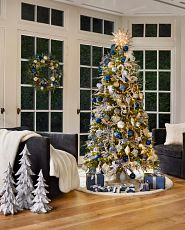 Pre-lit artificial Christmas tree decorated with blue and white ornaments