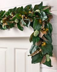 Artificial magnolia leaf garland on white front door