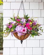Pink and purple artificial flowers in a hanging basket arrangement