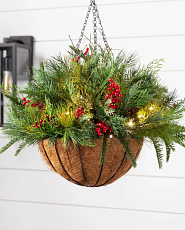 Artificial evergreens with red berries and pinecones in a hanging basket