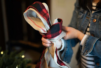 Hands looping two layers of Christmas tree ribbons