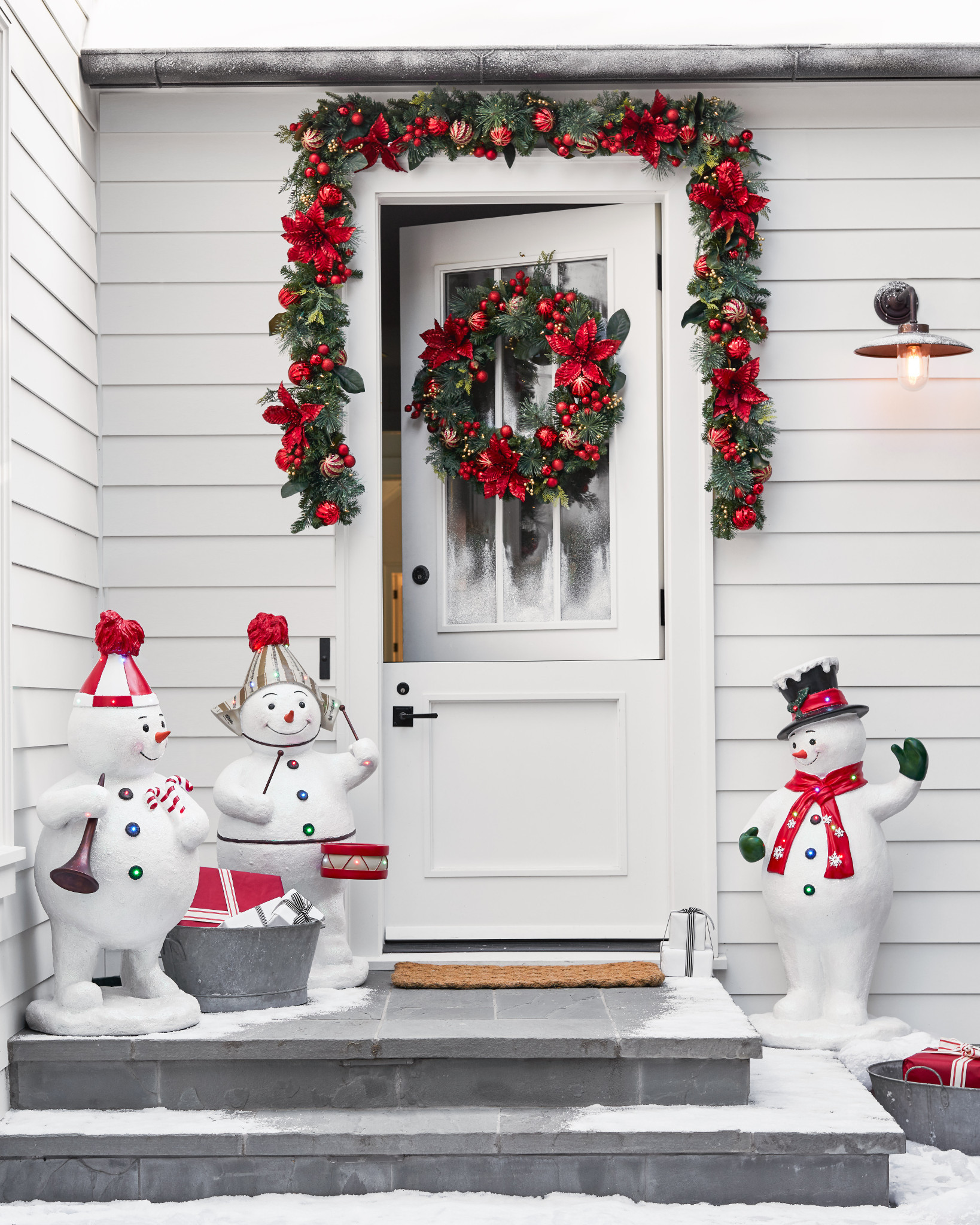 White door with artificial poinsettia wreath and garland