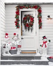 Porte d'entrée blanche avec couronne de Noël et bonhomme de neige