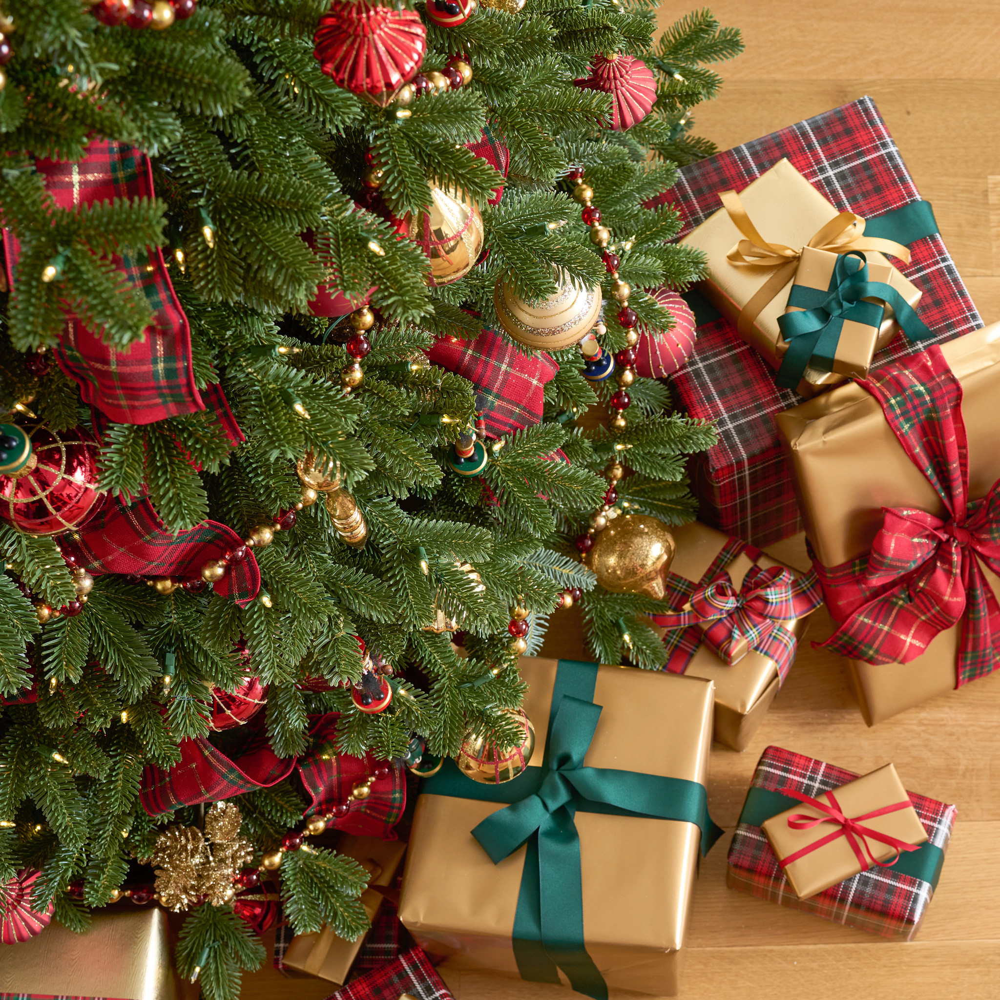 Closeup of Christmas tree with presents wrapped in gold paper
