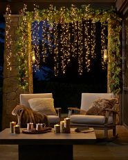 Patio seating area decorated with lights and greenery