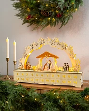 Beistelltisch mit Adventskalender aus Holz, Kerzen und immergrüner Deko