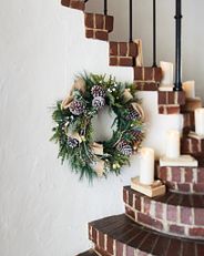 A wreath hanging on a wall near a staircase