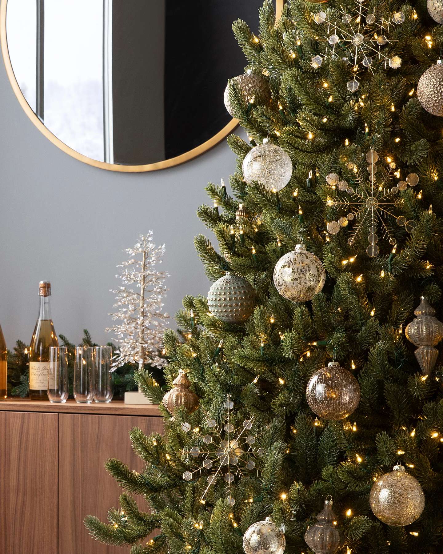 Balsam Hill Burnished Metals Christmas Ornament Set Lifestyle Tree Display with Mirror in the Background Closeup