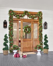 Front door decorated with Christmas wreaths, garlands, and topiaries