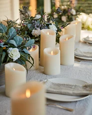LED pillar candles with a garland table runner on a dining table
