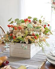 Artificial flower arrangement with hydrangeas, white berries, pinecones, rose hips, and mixed leaves
