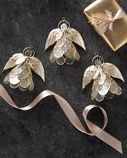 Three angel capiz Christmas ornaments on a gray background