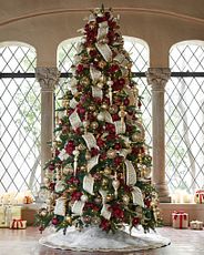 Giant artificial Christmas tree decorated with white and gold ornaments and tree skirt