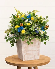 Artificial potted flowers with gerberas, cornflowers, wildflowers, ivy, and pomegranates