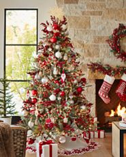 Artificial Christmas tree decorated with red and white ornaments and tree skirt