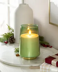 Lit candle in green glass holder