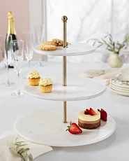 White marble three-tier serving stand with desserts on a white dining table