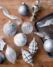 Silver and gray glass Christmas ornaments on wood background