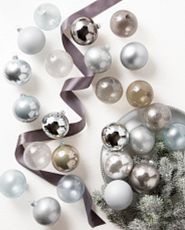 Assorted ball ornaments in various shades of silver on white background