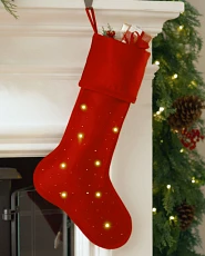 Lit red Christmas stocking on mantel