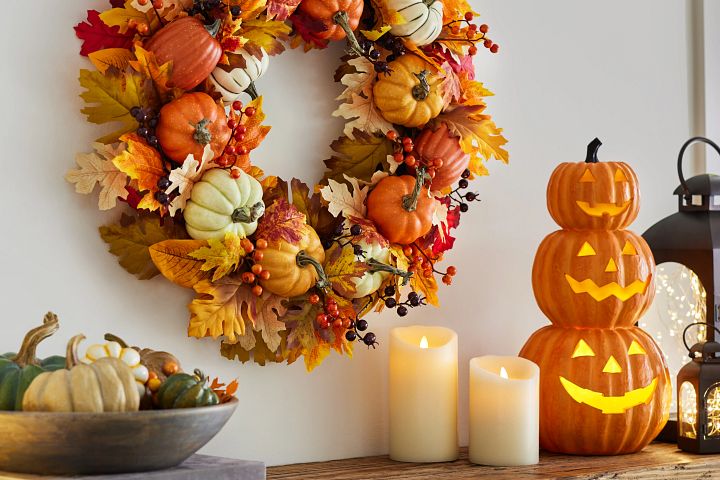 Mantel with artificial pumpkin wreath and stacked Jack-o’Lanterns