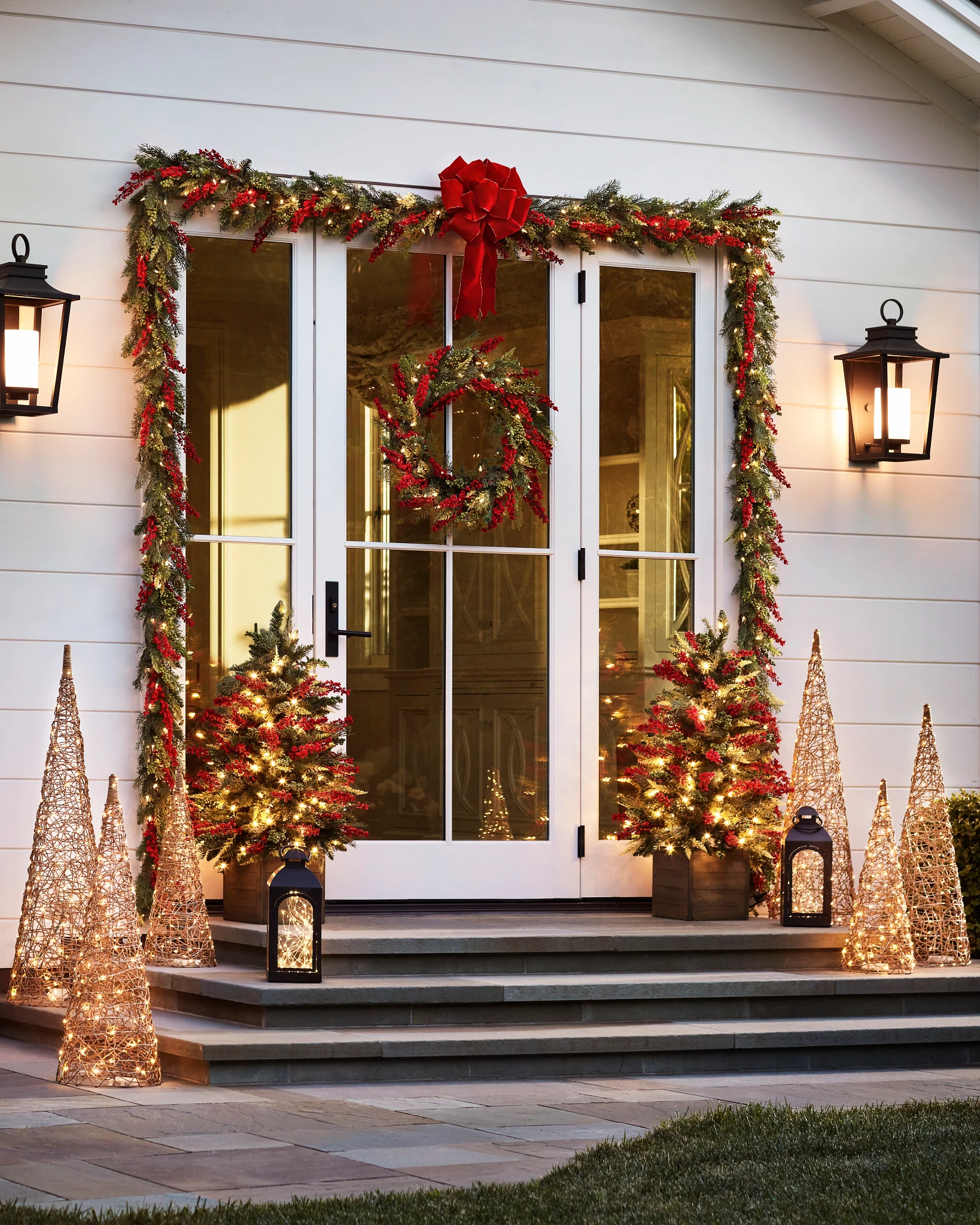 Patio décoré avec des lumières de Noël et des compositions végétales